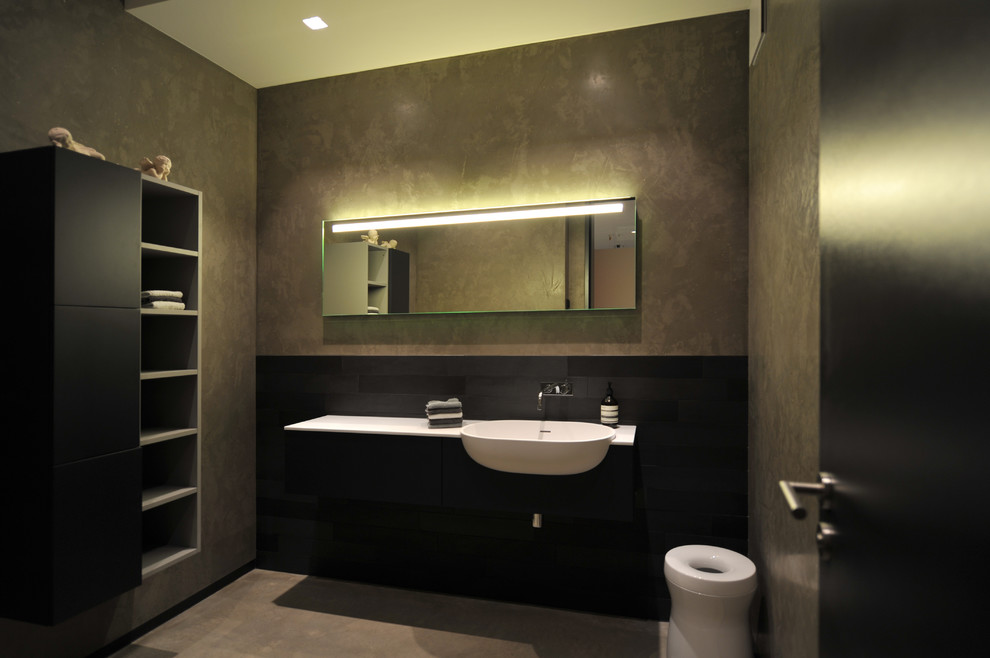 Diseño de cuarto de baño contemporáneo grande con baldosas y/o azulejos negros, paredes grises, armarios abiertos, puertas de armario negras, lavabo encastrado y espejo con luz