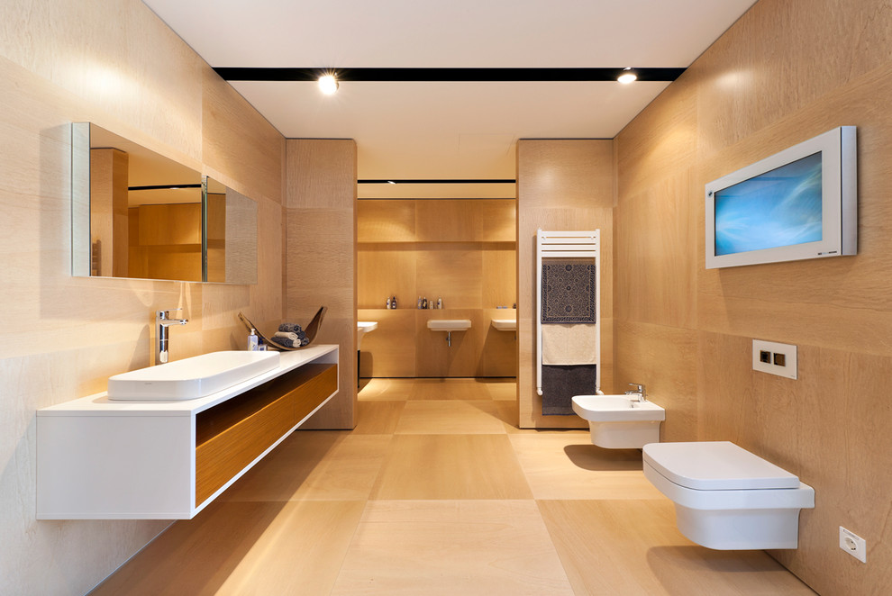 Modelo de cuarto de baño contemporáneo grande con armarios abiertos, puertas de armario de madera clara, bidé, paredes marrones, suelo de madera en tonos medios y lavabo sobreencimera