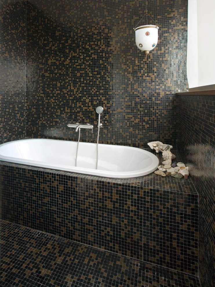 Modern inredning av ett badrum, med ett badkar i en alkov, brun kakel, svart kakel, mosaik, flerfärgade väggar och mosaikgolv
