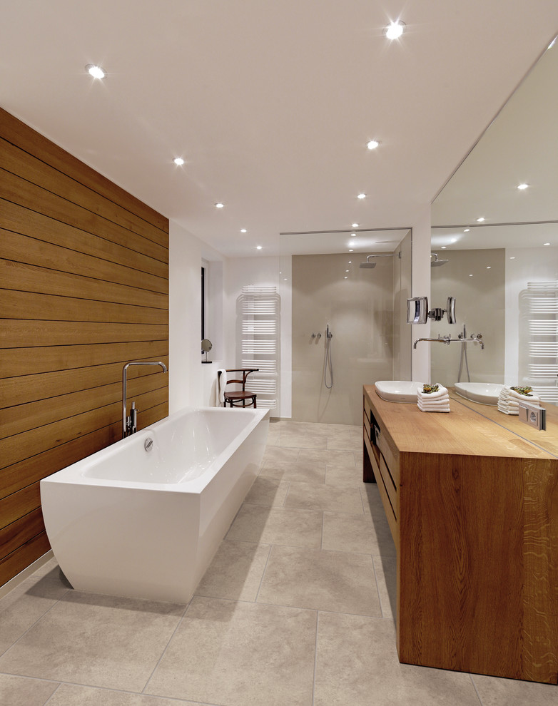 Foto på ett stort funkis badrum, med ett nedsänkt handfat, släta luckor, skåp i mellenmörkt trä, träbänkskiva, ett fristående badkar, en kantlös dusch, beige kakel, vita väggar och vinylgolv