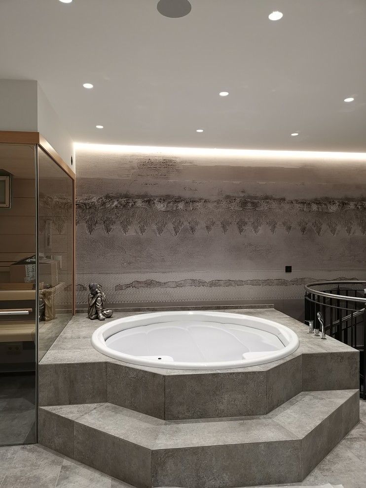 На фото: большая ванная комната в современном стиле с накладной ванной и серым полом с