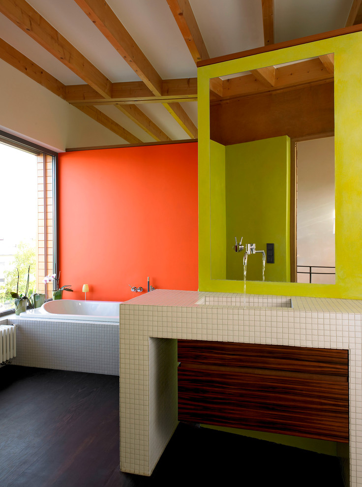 Esempio di una stanza da bagno contemporanea di medie dimensioni con ante lisce, ante in legno bruno, piastrelle beige, piastrelle a mosaico, pareti multicolore, parquet scuro e lavabo integrato