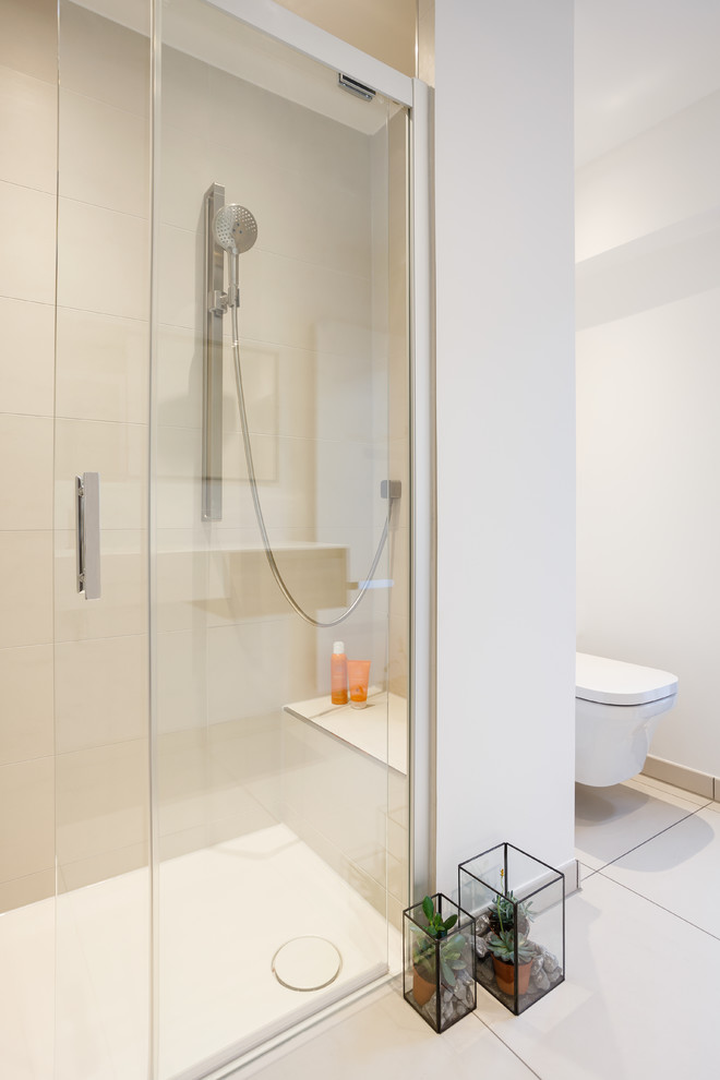 Kleines Modernes Duschbad mit bodengleicher Dusche, Wandtoilette, beigen Fliesen, Keramikfliesen, weißer Wandfarbe, Keramikboden, beigem Boden, Schiebetür-Duschabtrennung und Pflanzen in Köln