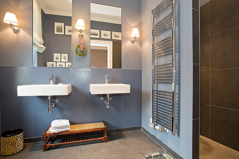 Immagine di una stanza da bagno contemporanea di medie dimensioni con pareti blu e lavabo sospeso