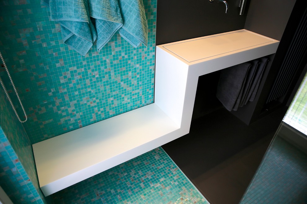 Bild på ett mellanstort funkis badrum med dusch, med släta luckor, grå skåp, mosaik, ett avlångt handfat och bänkskiva i akrylsten