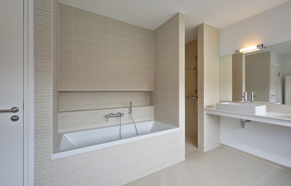 На фото: большая ванная комната в современном стиле с ванной в нише, душем в нише, бежевой плиткой, удлиненной плиткой, белыми стенами и настольной раковиной с