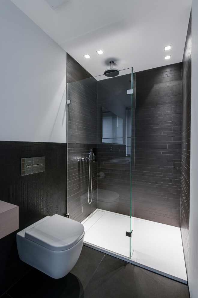This is an example of a small contemporary shower room bathroom in Cologne with a wall mounted toilet, an open shower, black tiles, white walls, black floors, light wood cabinets, a built-in shower, matchstick tiles, an integrated sink, wooden worktops, beige worktops, a wall niche, a single sink, a floating vanity unit and a drop ceiling.