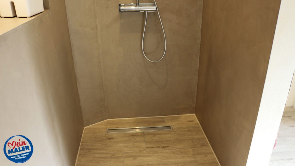 Imagen de cuarto de baño actual de tamaño medio con paredes marrones, imitación a madera, aseo y ducha y suelo marrón