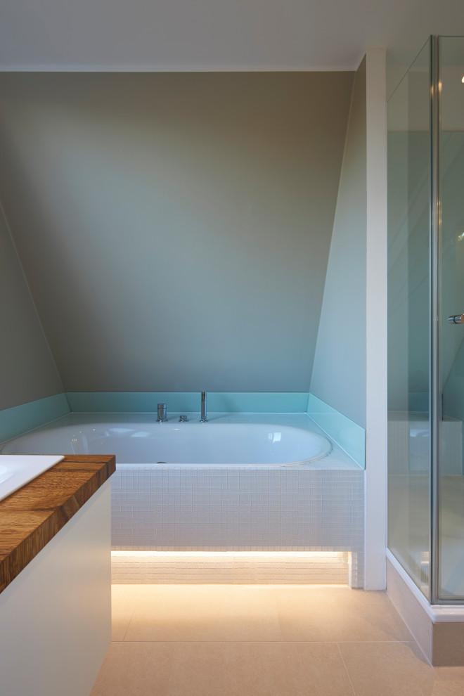 Foto på ett funkis brun en-suite badrum, med vita skåp, ett platsbyggt badkar, en dusch i en alkov, en vägghängd toalettstol, vit kakel, mosaik, beige väggar, kalkstensgolv och brunt golv