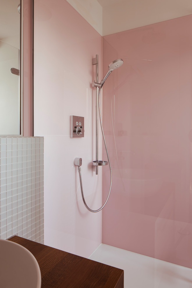 Modernes Duschbad mit weißen Schränken, bodengleicher Dusche, Wandtoilette, weißen Fliesen, Mosaikfliesen, rosa Wandfarbe, dunklem Holzboden, braunem Boden, brauner Waschtischplatte, Einzelwaschbecken und freistehendem Waschtisch in Düsseldorf