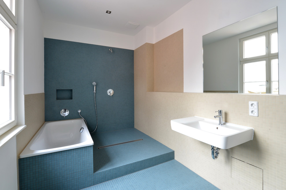 Réalisation d'une salle de bain minimaliste de taille moyenne avec un lavabo suspendu, un carrelage bleu, un carrelage beige, mosaïque, un mur beige, un sol en carrelage de terre cuite, une baignoire posée, une douche ouverte et aucune cabine.