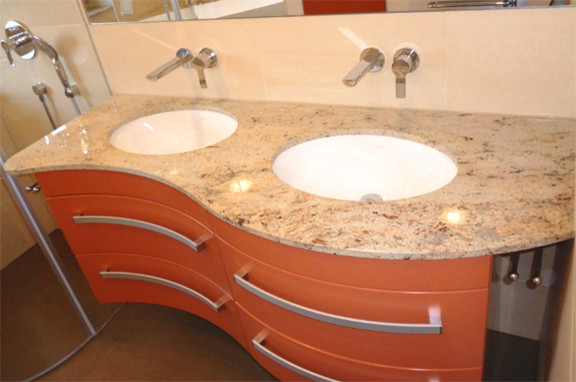 Cette photo montre une salle de bain tendance de taille moyenne avec des portes de placard oranges, un carrelage beige, un carrelage de pierre, carreaux de ciment au sol, un lavabo encastré et un plan de toilette en granite.