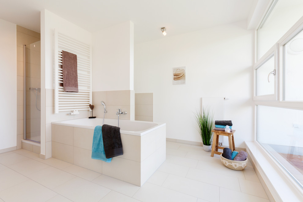 Modern inredning av ett stort badrum, med ett platsbyggt badkar, beige kakel, vita väggar och en dusch i en alkov