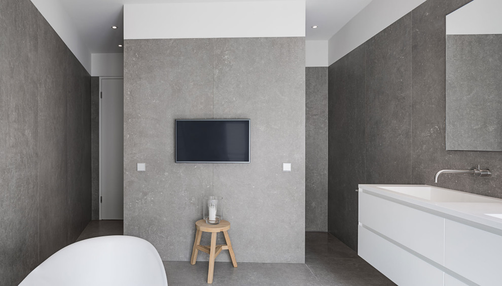 На фото: ванная комната в современном стиле с отдельно стоящей ванной, серыми стенами, врезной раковиной, столешницей из искусственного камня, серым полом и белой столешницей с