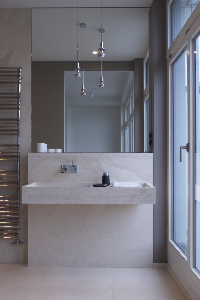 Esempio di una stanza da bagno con doccia minimal di medie dimensioni con doccia a filo pavimento, WC sospeso, piastrelle beige, pareti grigie, pavimento beige, doccia aperta e lavabo sospeso
