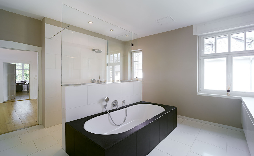 Inspiration för mycket stora moderna badrum, med släta luckor, vita skåp, vit kakel, porslinskakel, beige väggar, klinkergolv i porslin, ett platsbyggt badkar och en kantlös dusch