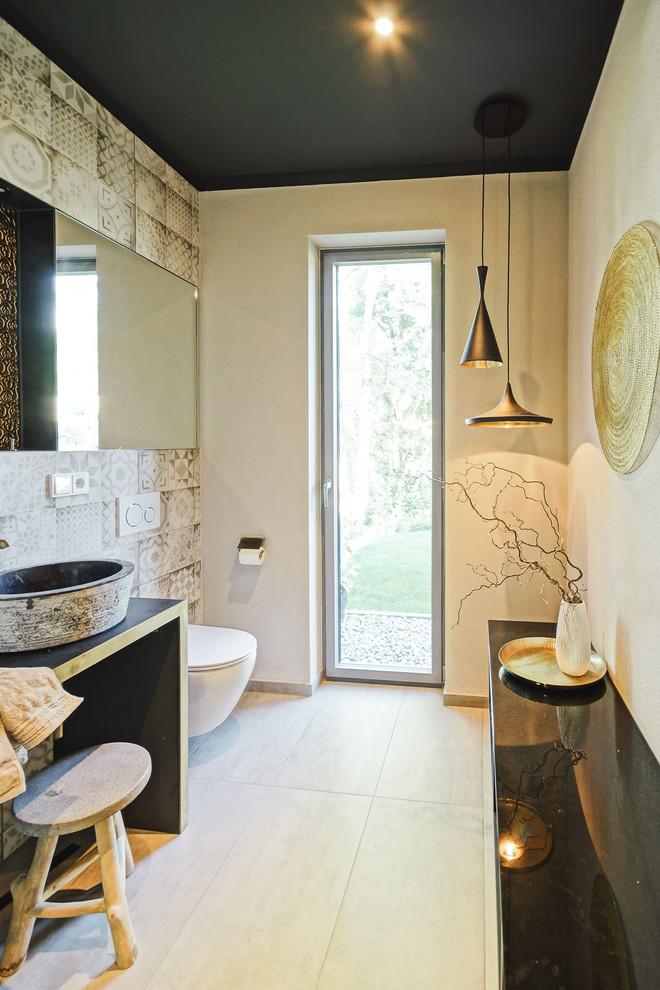 Kleines Mediterranes Duschbad mit Wandtoilette, beigen Fliesen, braunen Fliesen, beiger Wandfarbe, Zementfliesen für Boden, Aufsatzwaschbecken, beigem Boden und Quarzit-Waschtisch in München