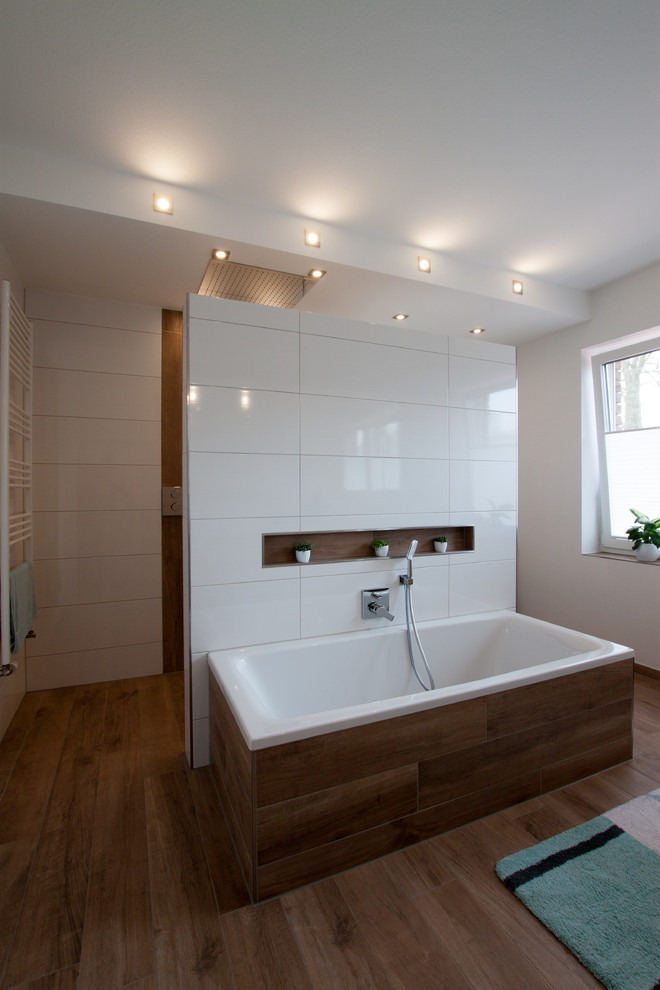 Idéer för att renovera ett mellanstort funkis badrum med dusch, med ett platsbyggt badkar, en öppen dusch, vita väggar, brunt golv, med dusch som är öppen, vit kakel, porslinskakel och mellanmörkt trägolv