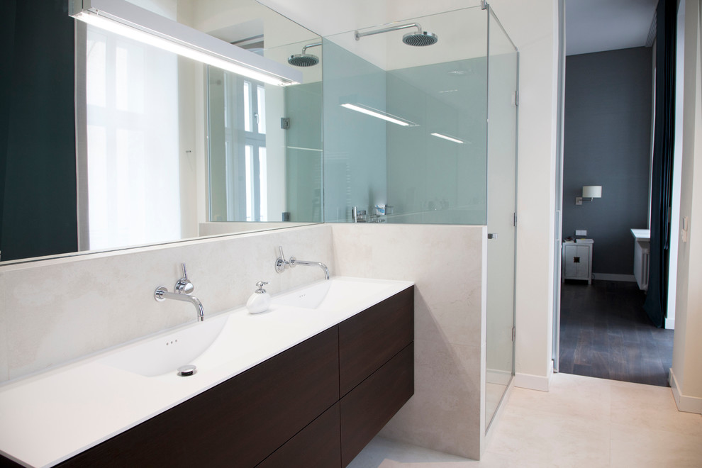 Medium sized contemporary bathroom in Berlin with an integrated sink, flat-panel cabinets, dark wood cabinets, a built-in shower, beige tiles, white walls, stone slabs and limestone flooring.