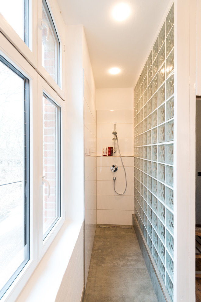 Idee per una stanza da bagno con doccia minimal di medie dimensioni con doccia alcova, piastrelle bianche, piastrelle in ceramica, pareti bianche e pavimento in cemento