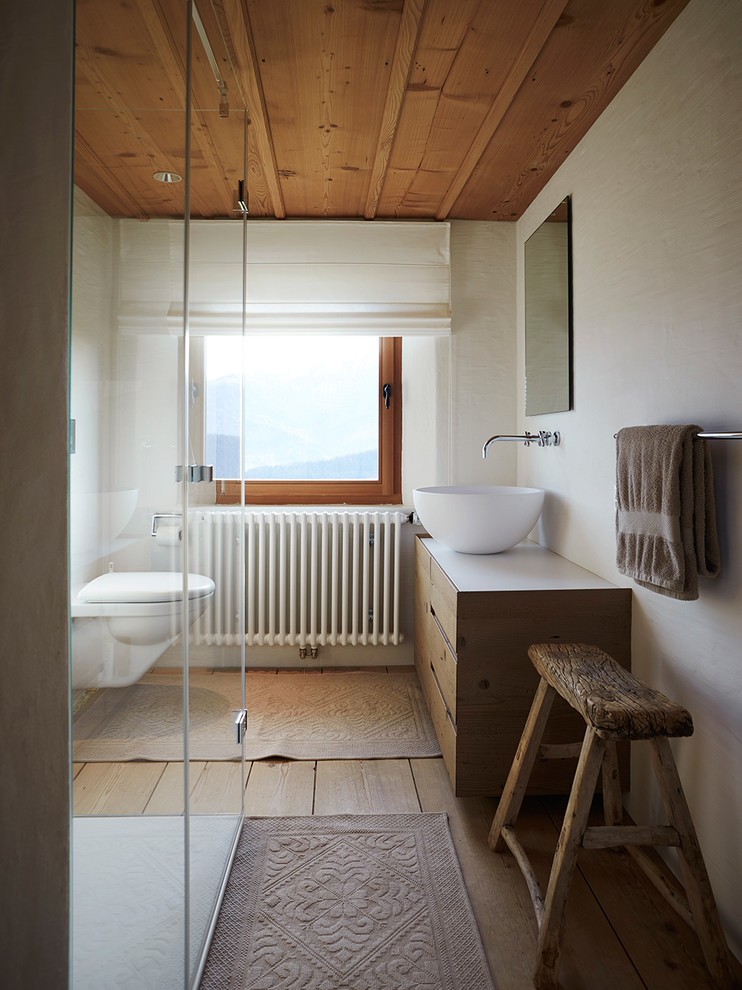 Cette photo montre une petite salle de bain montagne en bois brun avec un placard à porte plane, une douche à l'italienne, WC suspendus, un mur beige, un sol en bois brun, une vasque et un plan de toilette en bois.