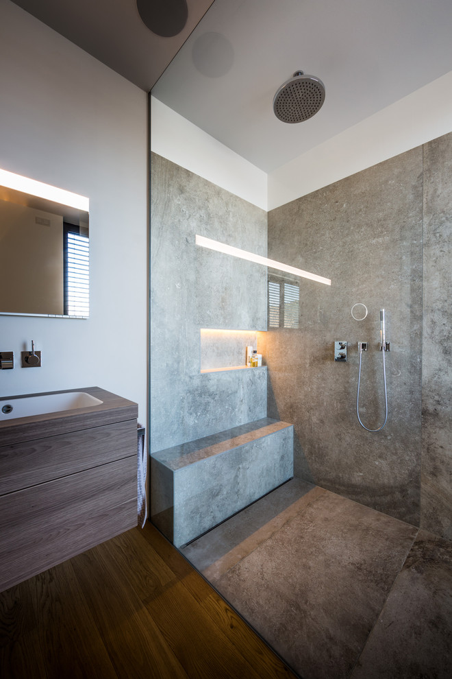 Inredning av ett modernt mellanstort brun brunt badrum med dusch, med släta luckor, skåp i ljust trä, en kantlös dusch, vita väggar, mörkt trägolv, ett undermonterad handfat, brunt golv, med dusch som är öppen och träbänkskiva