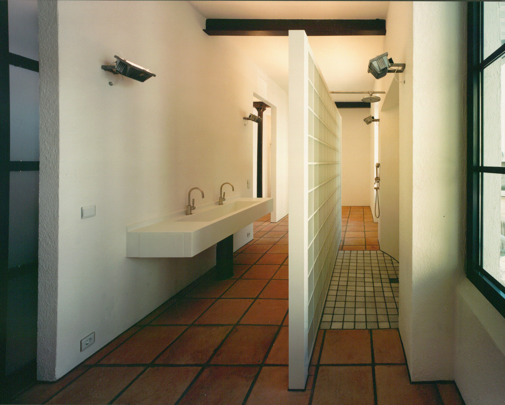 Ispirazione per una stanza da bagno con doccia minimal con doccia a filo pavimento, piastrelle in terracotta, pareti bianche e pavimento in terracotta