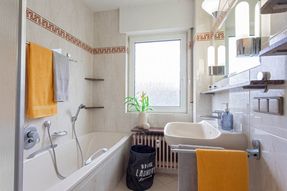 Idee per una stanza da bagno minimal con vasca ad alcova, vasca/doccia, piastrelle grigie, pareti bianche, lavabo sospeso, pavimento grigio e un lavabo