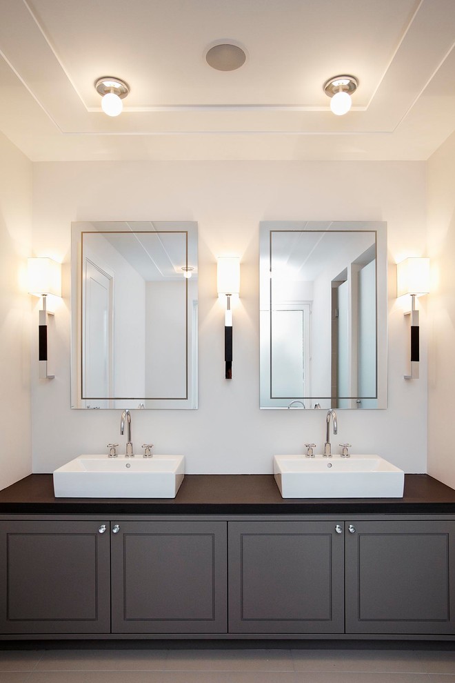 This is an example of a medium sized contemporary bathroom in Hamburg with raised-panel cabinets, dark wood cabinets, white walls and a vessel sink.