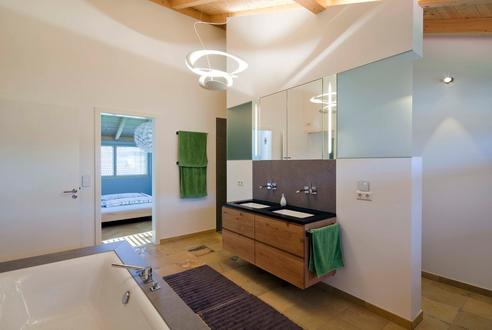 Источник вдохновения для домашнего уюта: большая ванная комната в современном стиле с плоскими фасадами, фасадами цвета дерева среднего тона, накладной ванной, белыми стенами, душевой кабиной, монолитной раковиной, синим полом и черной столешницей