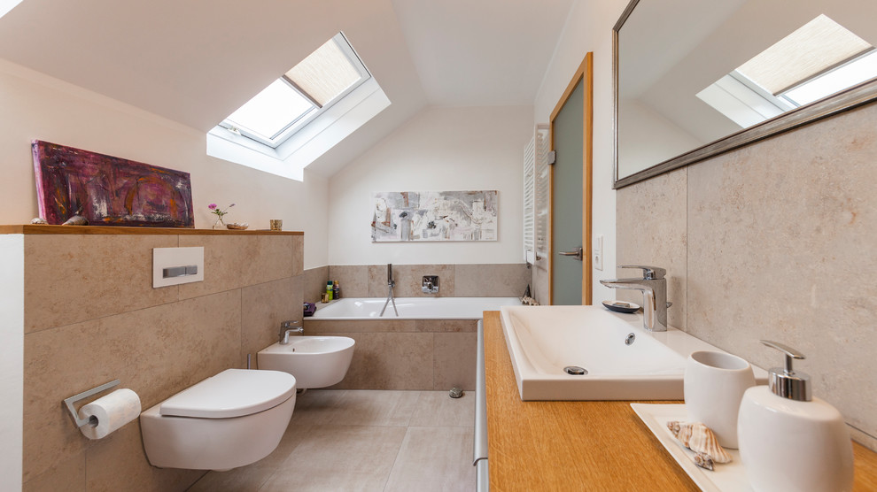 Großes Modernes Badezimmer mit Einbaubadewanne, Bidet, beigen Fliesen, weißer Wandfarbe, Einbauwaschbecken, Waschtisch aus Holz, beigem Boden und brauner Waschtischplatte in Sonstige