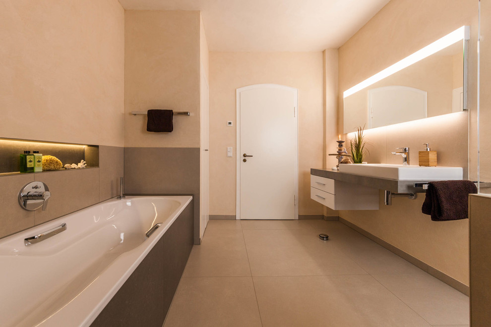 他の地域にある中くらいなコンテンポラリースタイルのおしゃれなバスルーム (浴槽なし) (フラットパネル扉のキャビネット、白いキャビネット、ドロップイン型浴槽、シャワー付き浴槽	、ベージュのタイル、セメントタイル、ベージュの壁、セメントタイルの床、ベッセル式洗面器、ベージュの床) の写真