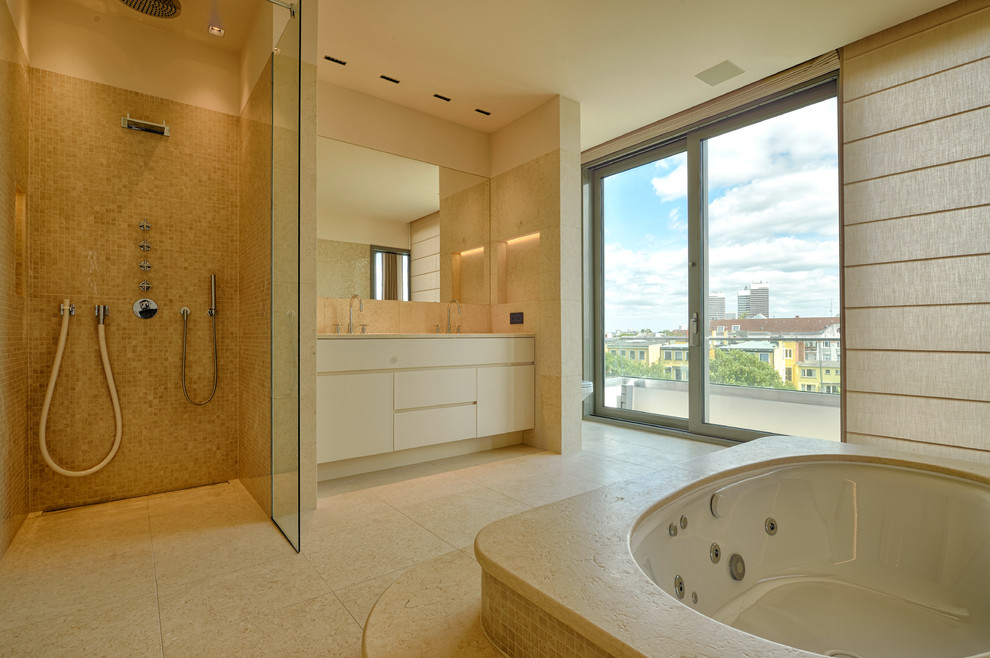 На фото: большая ванная комната в современном стиле с плоскими фасадами, белыми фасадами, накладной ванной, угловым душем, бежевой плиткой, бежевыми стенами, накладной раковиной, каменной плиткой и окном с