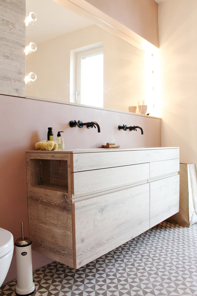 Aménagement d'une salle de bain moderne en bois brun avec un placard à porte plane et un mur rose.