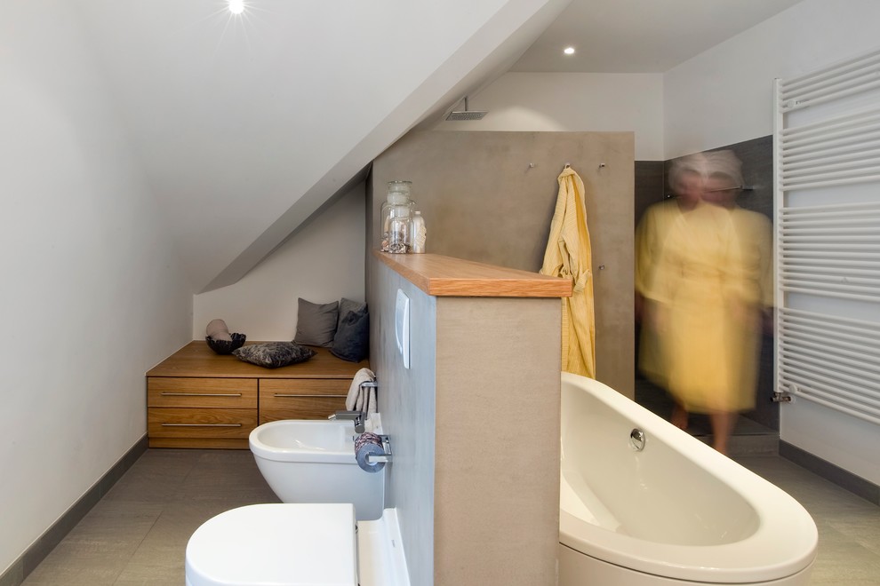 Modernes Badezimmer mit freistehender Badewanne, offener Dusche und Wandtoilette in München