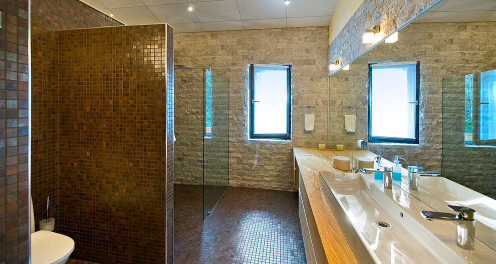 ベルリンにあるコンテンポラリースタイルのおしゃれな浴室 (横長型シンク、木製洗面台、バリアフリー、茶色いタイル、モザイクタイル、モザイクタイル、フラットパネル扉のキャビネット、中間色木目調キャビネット) の写真