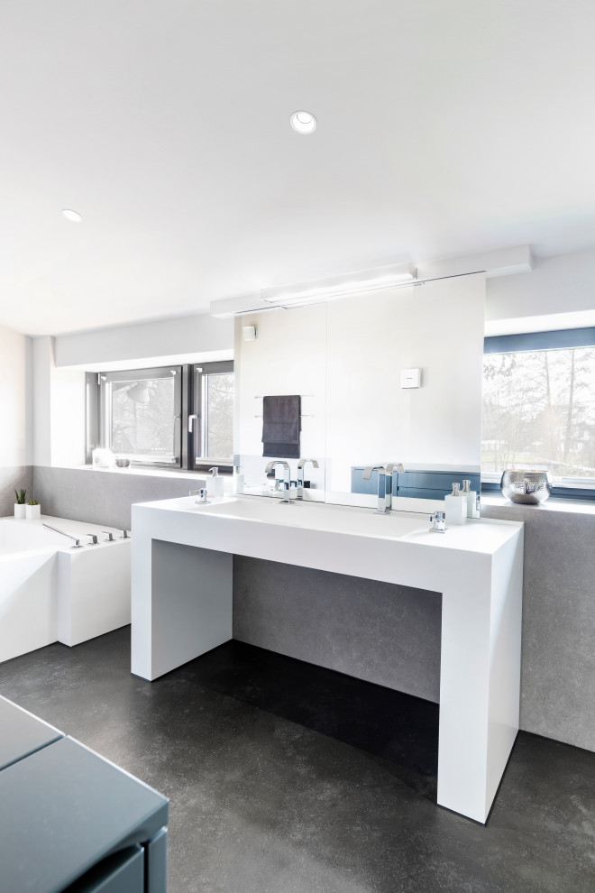 Пример оригинального дизайна: большая ванная комната в современном стиле с открытыми фасадами, белыми фасадами, ванной в нише, серой плиткой, белыми стенами, раковиной с несколькими смесителями, черным полом и белой столешницей