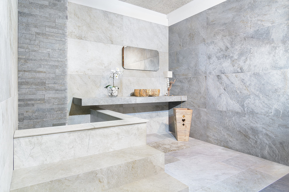 Modelo de cuarto de baño principal actual de tamaño medio con baldosas y/o azulejos de piedra y lavabo sobreencimera