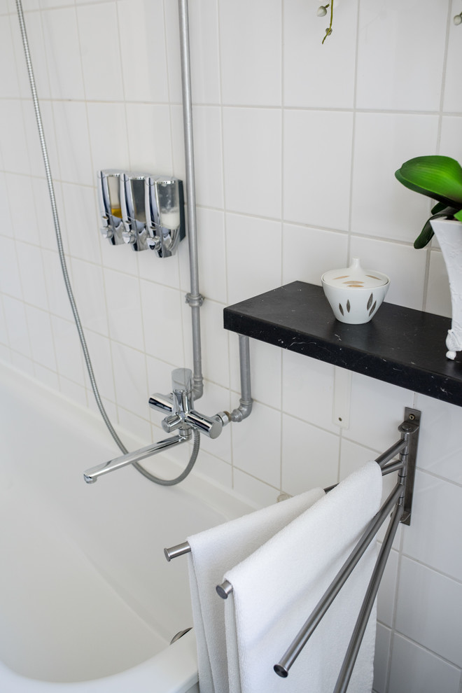 Eklektisches Badezimmer mit weißen Schränken, Einbaubadewanne, Keramikfliesen, weißer Wandfarbe, integriertem Waschbecken, schwarzem Boden und schwarzer Waschtischplatte in Berlin