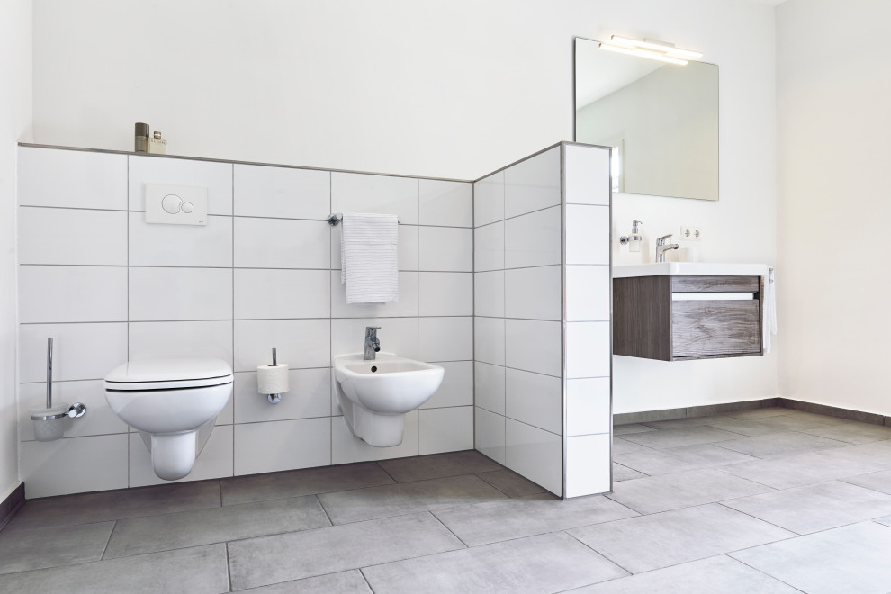 Idéer för ett stort modernt brun badrum med dusch, med släta luckor, bruna skåp, ett undermonterat badkar, en hörndusch, en toalettstol med separat cisternkåpa, vit kakel, porslinskakel, vita väggar, grått golv och dusch med gångjärnsdörr