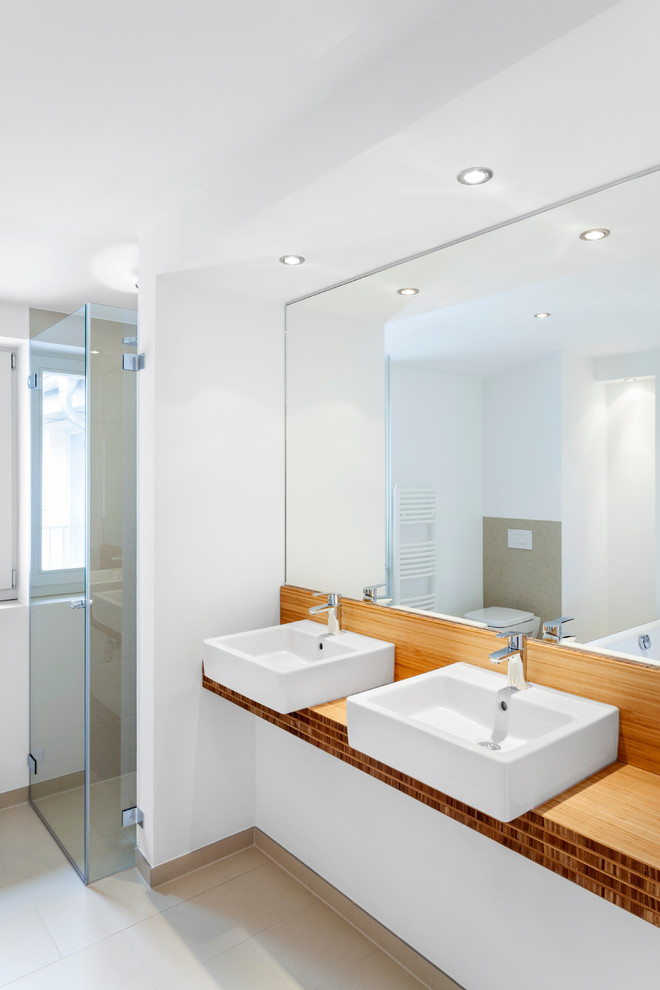 Idée de décoration pour une douche en alcôve design de taille moyenne avec un carrelage beige, un mur blanc, un plan de toilette en bois et une vasque.