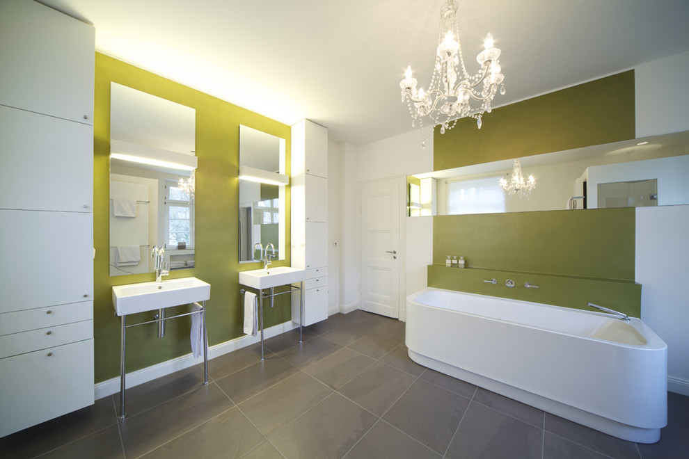 ケルンにある巨大なコンテンポラリースタイルのおしゃれな浴室 (フラットパネル扉のキャビネット、白いキャビネット、ドロップイン型浴槽、緑の壁、スレートの床、コンソール型シンク) の写真