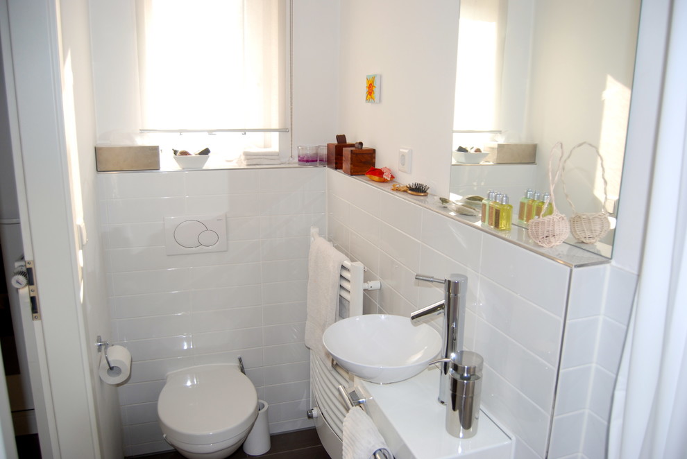 Foto de cuarto de baño actual pequeño con encimera de azulejos, ducha empotrada, sanitario de pared, baldosas y/o azulejos blancos, baldosas y/o azulejos de cerámica y paredes blancas