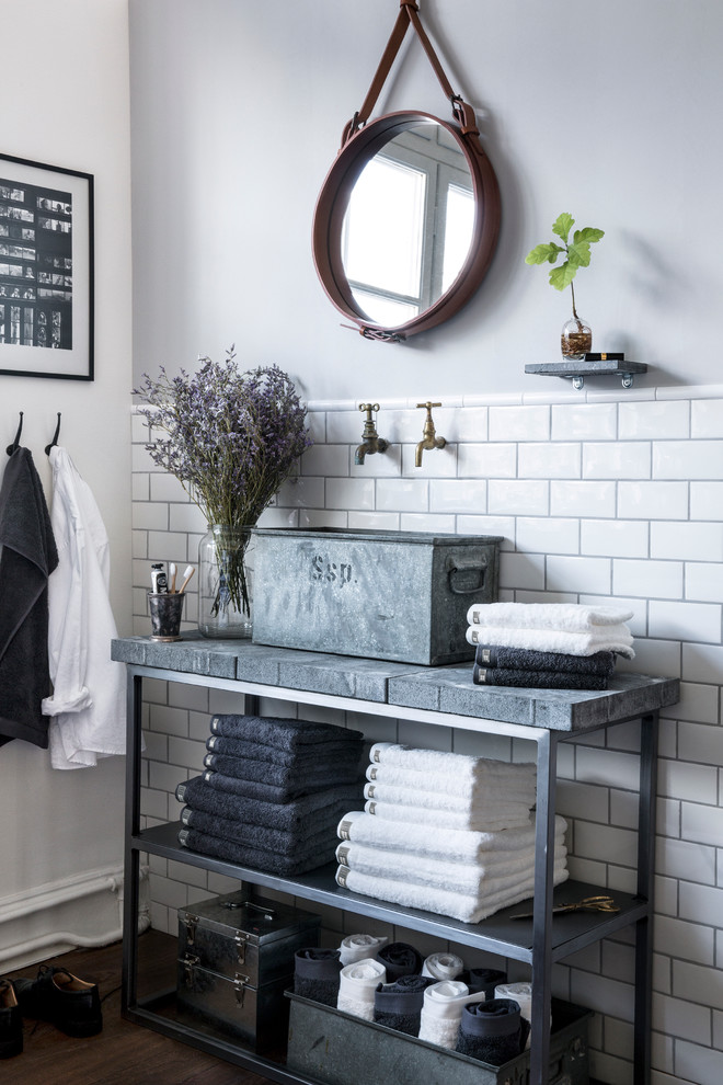 This is an example of a shabby-chic style bathroom in Berlin with a vessel sink, open cabinets, white walls, metro tiles, concrete worktops and dark hardwood flooring.
