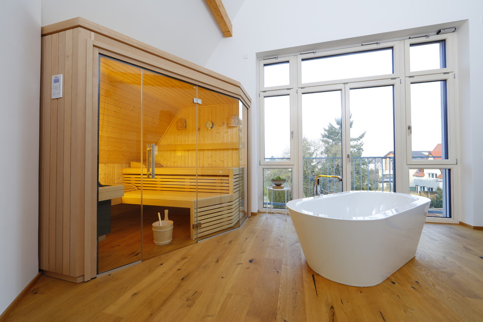 Mittelgroße Moderne Sauna mit freistehender Badewanne, weißer Wandfarbe, hellem Holzboden und beigem Boden in Sonstige