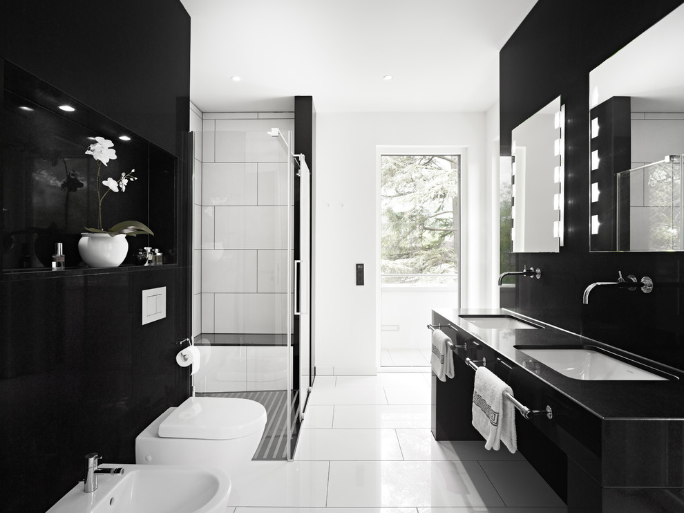 Идея дизайна: главная ванная комната среднего размера в современном стиле с угловым душем, инсталляцией, белыми стенами, врезной раковиной, плоскими фасадами, черными фасадами, черно-белой плиткой, керамогранитной плиткой, полом из керамической плитки, душем с раздвижными дверями и сиденьем для душа