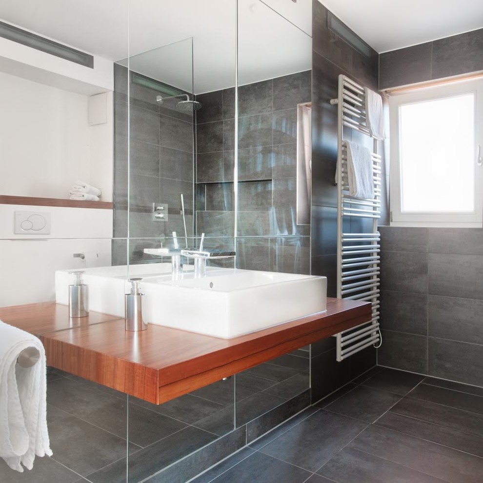 На фото: ванная комната среднего размера в современном стиле с угловым душем, серой плиткой, керамической плиткой, белыми стенами и столешницей из дерева