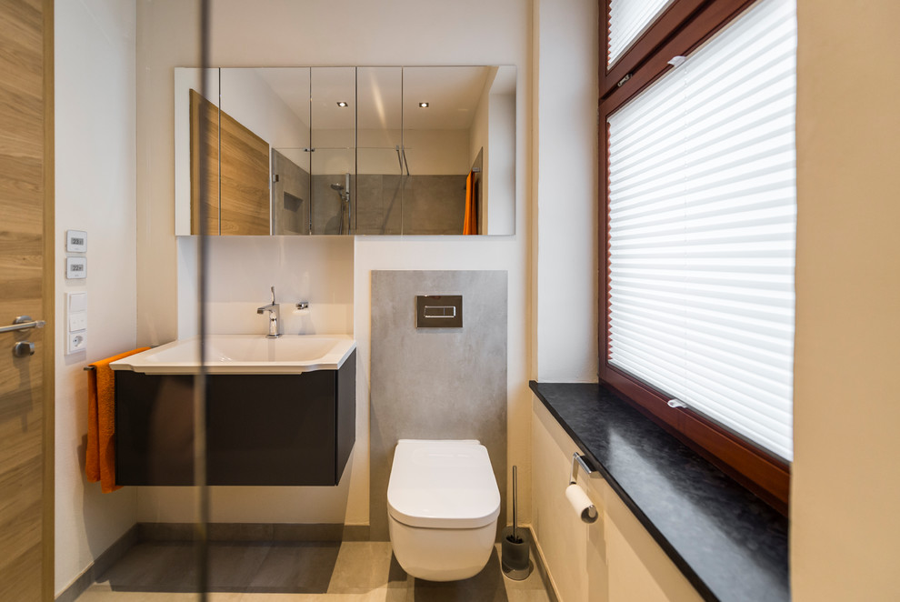 Mittelgroßes Modernes Duschbad mit grauen Schränken, freistehender Badewanne und weißer Waschtischplatte in Leipzig