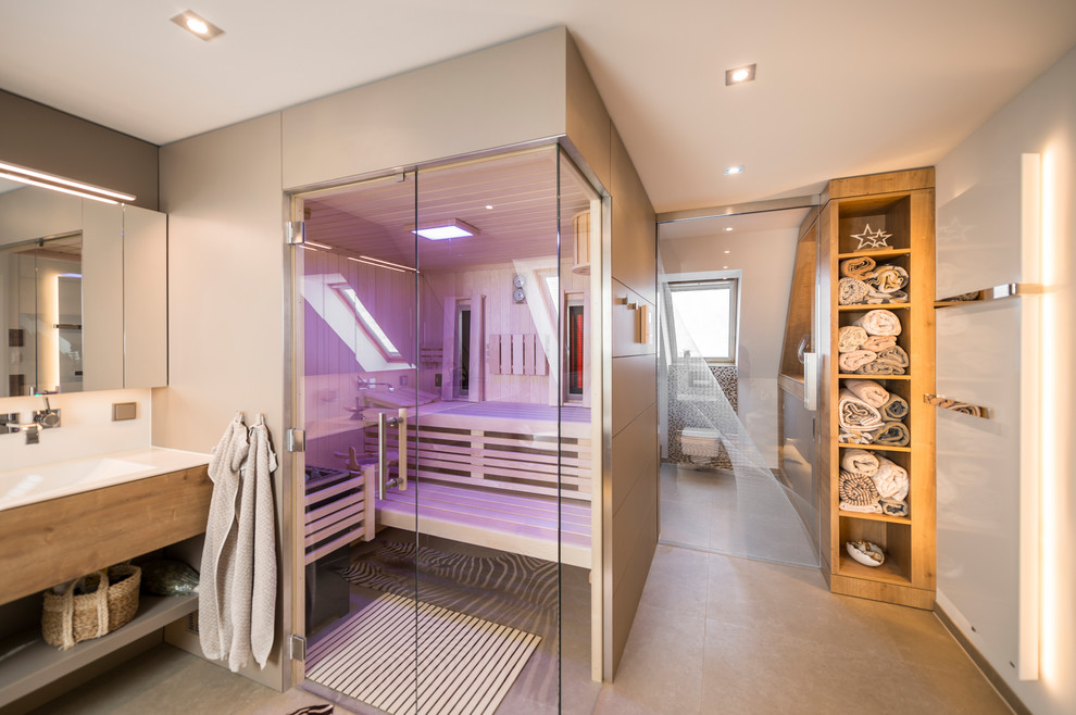 Mittelgroßes Modernes Badezimmer mit Einbaubadewanne, bodengleicher Dusche, Wandtoilette, integriertem Waschbecken, braunem Boden und Schiebetür-Duschabtrennung in Dresden