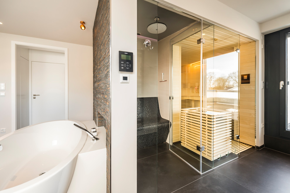 Exemple d'une grande salle d'eau tendance en bois foncé avec un placard à porte plane, une baignoire indépendante, une douche à l'italienne, un mur blanc, un plan de toilette en surface solide, un sol noir et un plan de toilette blanc.